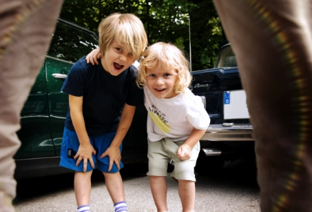 Deux joyeux garçons rient à la caméra sur le terrain extérieur de l'établissement Cocon Kids