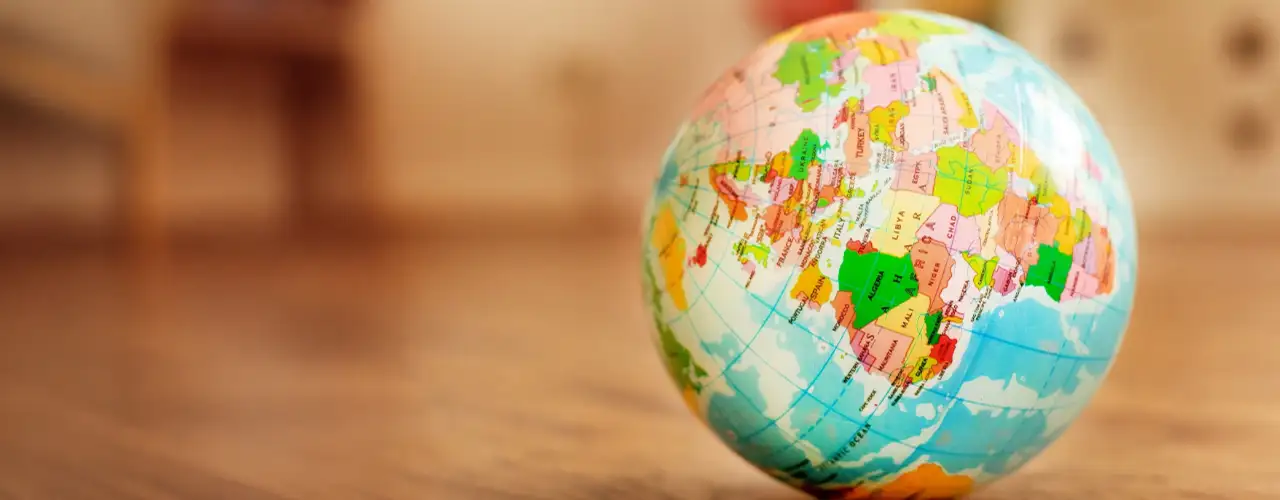 Bunter Globus auf Holzfußboden – Symbol für kulturelle Vielfalt und globale Bildung im Kindergarten