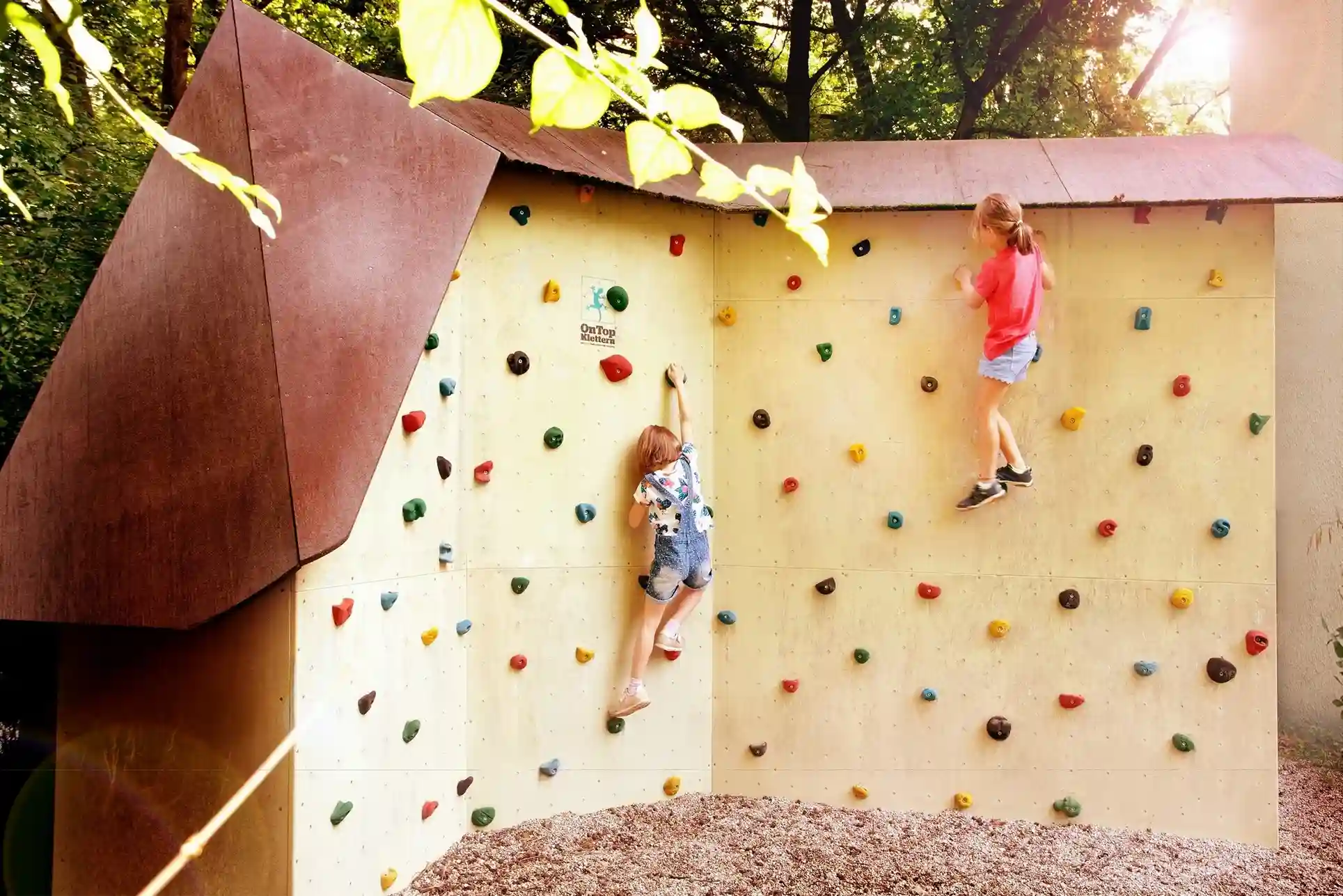 Kinder klettern im Kindergarten an einer Kletterwand